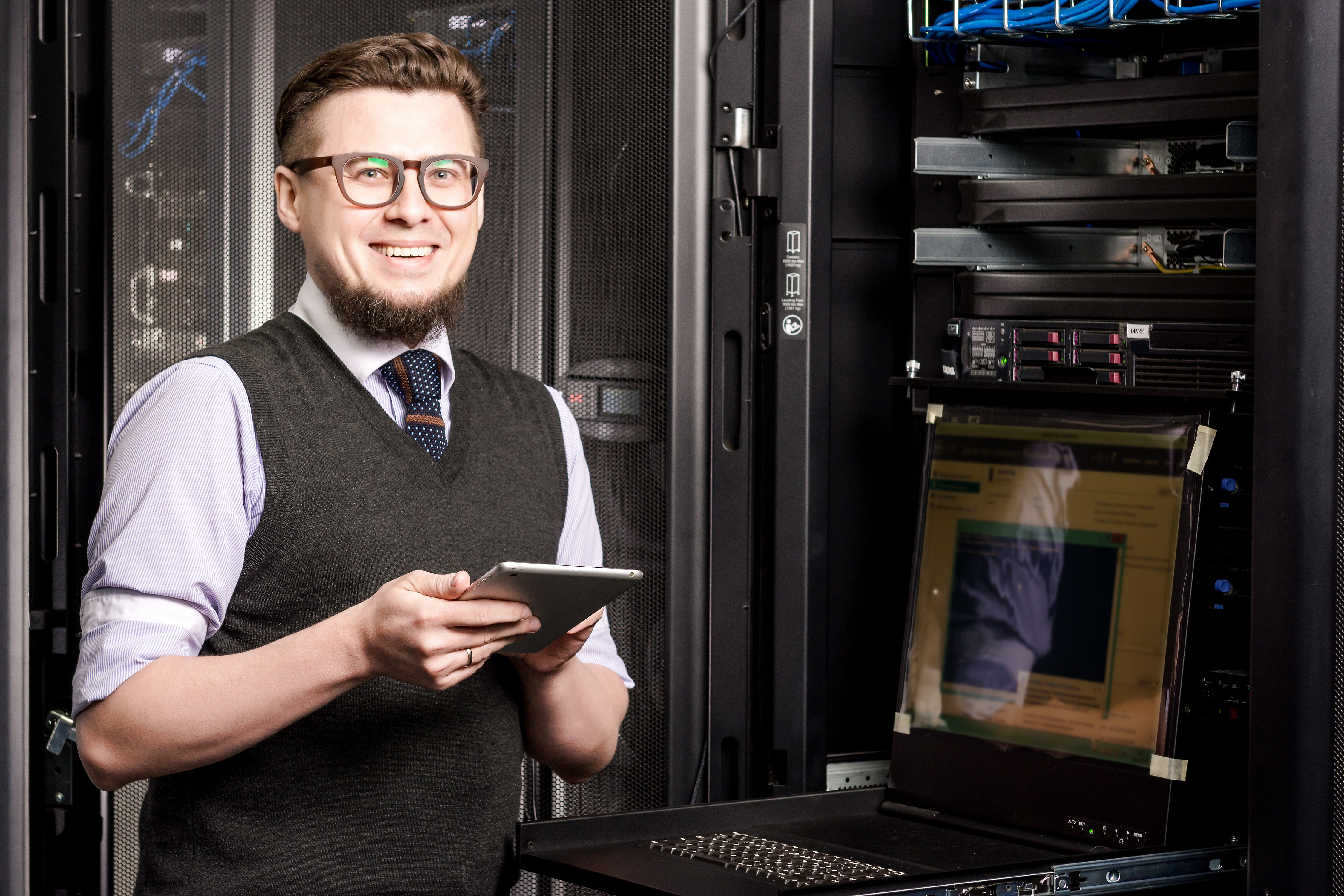 Young engineer wearing glasses in a datacenter